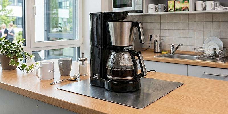 Bild: Feuerfeste Brandschutzunterlage aus Edelstahl unter einer Kaffeemaschine